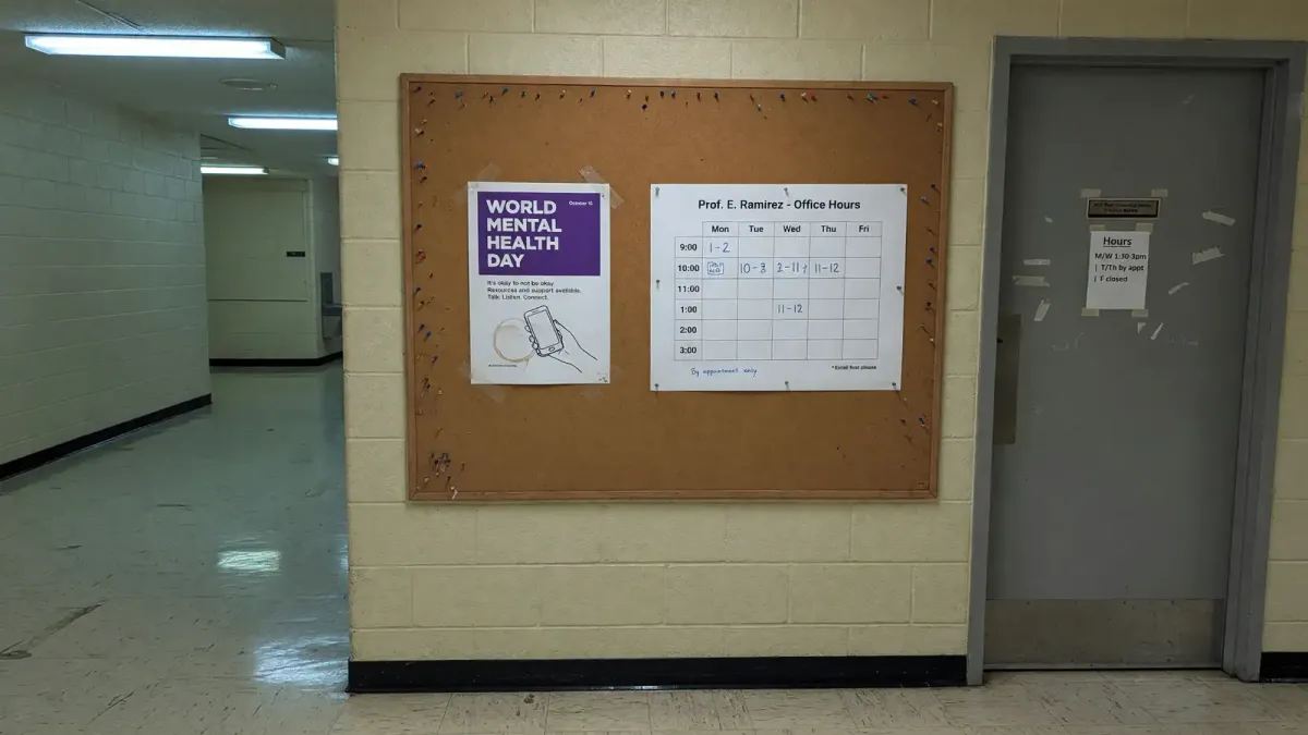 Campus hallway bulletin board with a World Mental Health Day flyer next to a printed counseling-center hours sheet, fluorescent light, no logos